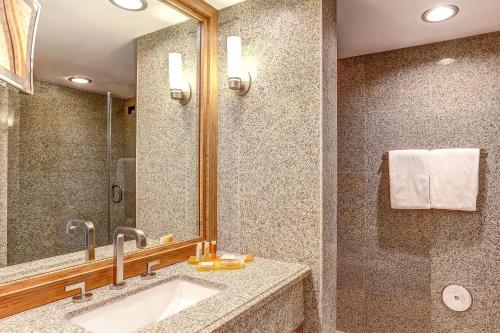 a bathroom with a sink and a shower at Avenue of the Arts Costa Mesa, a Tribute Portfolio Hotel in Costa Mesa