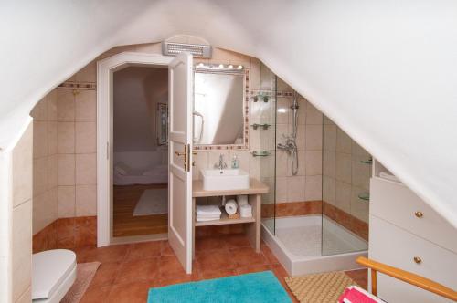 ein Badezimmer mit Waschbecken und Dusche auf einem Dachboden in der Unterkunft Villa Sea Mill in Mirce