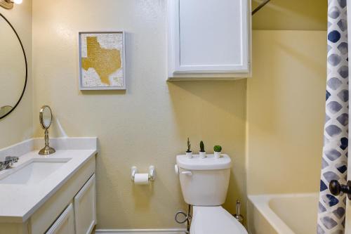 y baño con aseo blanco y lavamanos. en Waxahachie Townhome with Fire Pit - Near Downtown!, en Waxahachie