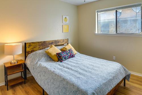 1 dormitorio con cama con sábanas azules y ventana en Waxahachie Townhome with Fire Pit - Near Downtown!, en Waxahachie