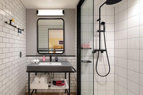 a bathroom with a sink and a mirror at Moxy Kyoto in Kyoto