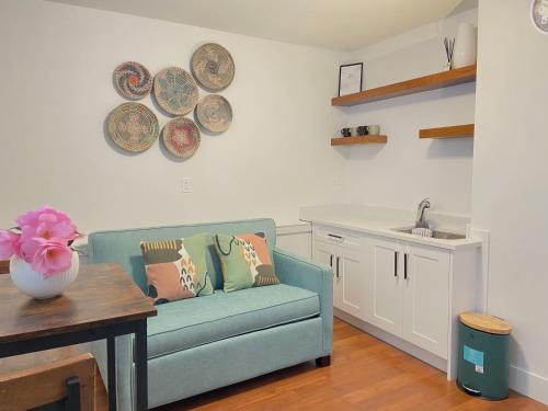 a living room with a blue couch and plates on the wall at Newly Renovated Walkout Basement in Vancouver with Separate Entrance in Vancouver