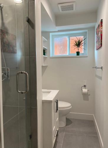 a bathroom with a shower and a toilet and a window at Newly Renovated Walkout Basement in Vancouver with Separate Entrance in Vancouver