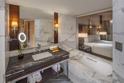 a bathroom with a tub and a sink and a bath tub at JW Marriott Mumbai Juhu in Mumbai