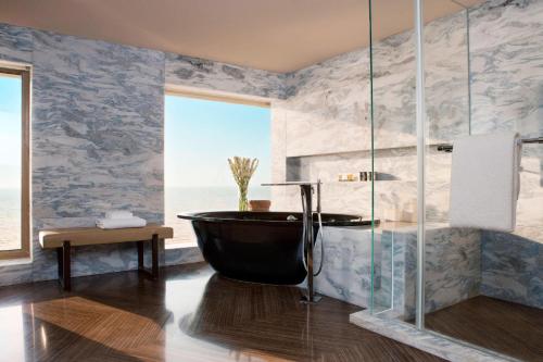 a bathroom with a bath tub and a view of the ocean at JW Marriott Mumbai Juhu in Mumbai