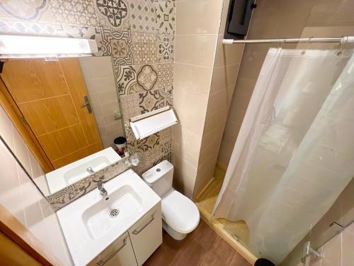 ein Bad mit einem WC, einem Waschbecken und einer Dusche in der Unterkunft Appartement Amwaj in Plage de Mehdia