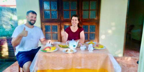 a man and woman sitting at a table giving thumbs up at ARANI HOMESTAY in Polonnaruwa