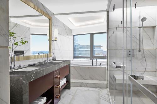 uma casa de banho com um chuveiro, um lavatório e uma banheira em JW Marriott Hotel Beijing Central em Pequim