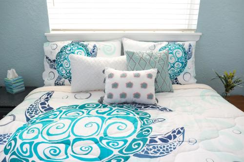 a bed with blue and white pillows and a window at License to Chill - Heated Pool, Indian Rocks Beach, Play Room in Largo