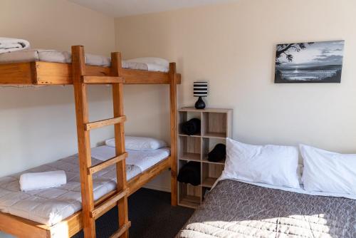 a bedroom with two bunk beds and a bed at Snow Denn Lodge in Methven