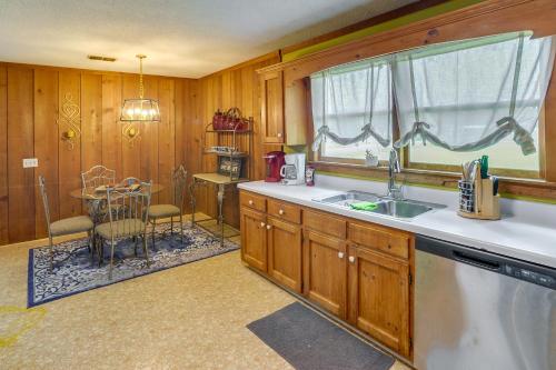eine Küche mit einem Waschbecken, einem Tisch und einem Fenster in der Unterkunft Pet-Friendly Hollywood Cabin Apartment Near Lake! 