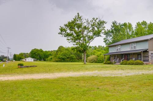 a house with a tree in a grass field at 6 Mi to Scottsboro Pet-Friendly Cabin Apt in Hollywood