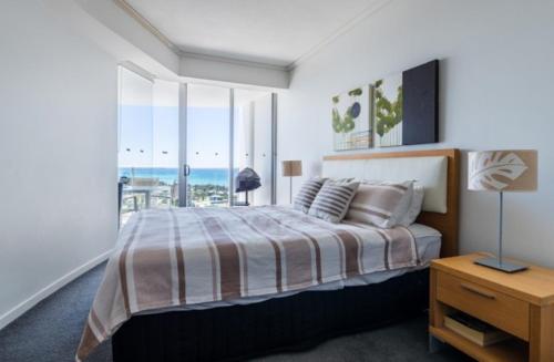 a bedroom with a bed with a view of the ocean at Resort Apartment with Ocean Views in Maroochydore