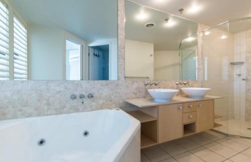 a bathroom with two sinks and a large mirror at Resort Apartment with Ocean Views in Maroochydore