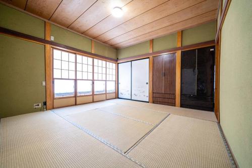 an empty room with a large room with windows at えのきや in Itoigawa