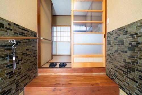 a room with a door and a brick wall at えのきや in Itoigawa
