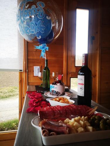 a table with a plate of food and a bottle of wine at Cabaña con vista a la laguna de Tota in Tota