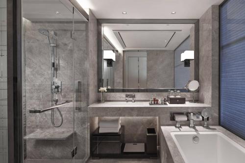 a bathroom with a tub and a sink and a shower at Shanghai Marriott Hotel Parkview in Shanghai