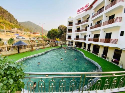 a swimming pool in front of a hotel at Heaven Hill Hotel & Hot Spring in Cham Ta Lao
