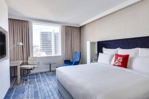 Habitación de hotel con cama grande y escritorio. en Sydney Harbour Marriott Hotel at Circular Quay en Sídney