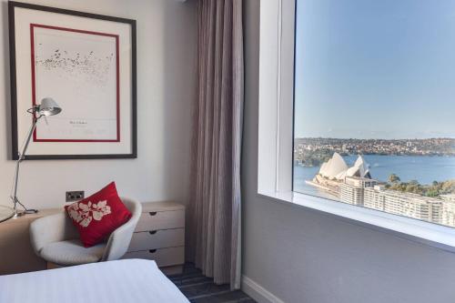 a hotel room with a window with a view of sydney at Sydney Harbour Marriott Hotel at Circular Quay in Sydney