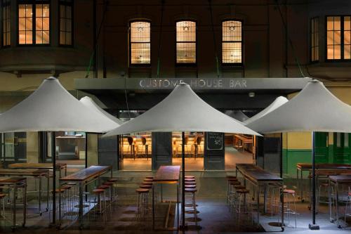 a group of tables and chairs under white umbrellas at Sydney Harbour Marriott Hotel at Circular Quay in Sydney