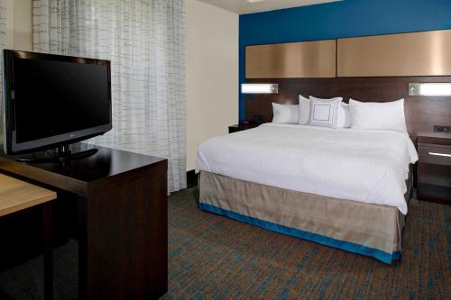 a hotel room with a bed and a flat screen tv at Residence Inn by Marriott Cleveland Mentor in Mentor