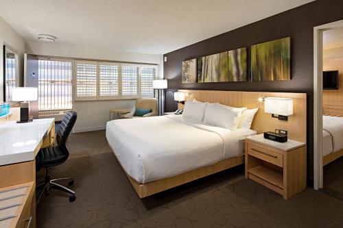 um quarto de hotel com uma cama grande e uma secretária em Delta Hotels by Marriott Winnipeg em Winnipeg