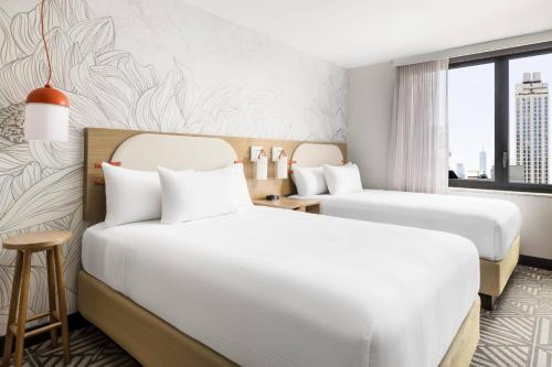 SpringHill Suites by Marriott New York Manhattan Chelsea في نيويورك: غرفة فندقية بسريرين ونافذة
