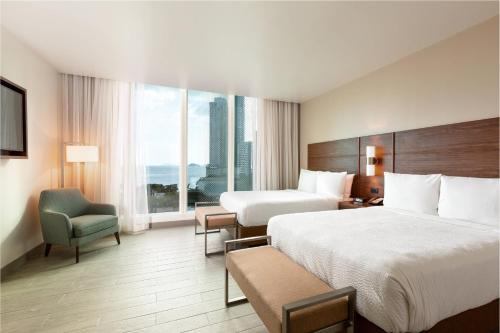 a hotel room with two beds and a large window at Residence Inn by Marriott Panama City in Panama City