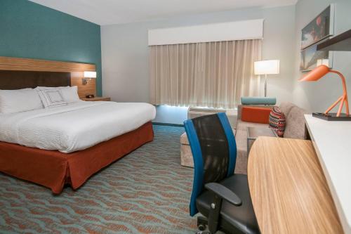 VidaliaにあるTownePlace Suites by Marriott Vidalia Riverfrontのベッド、デスク、椅子が備わるホテルルームです。