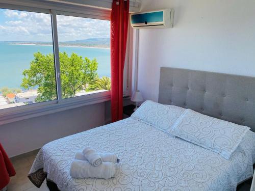 a bedroom with a bed and a large window at SAN ANTONIO in Piriápolis