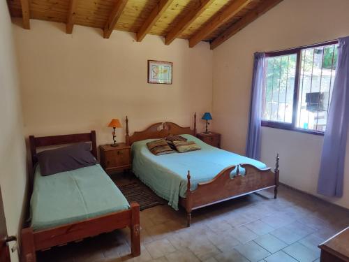 - une chambre avec 2 lits et une fenêtre dans l'établissement Cabañas Pequeño Paraíso, à Tunuyán
