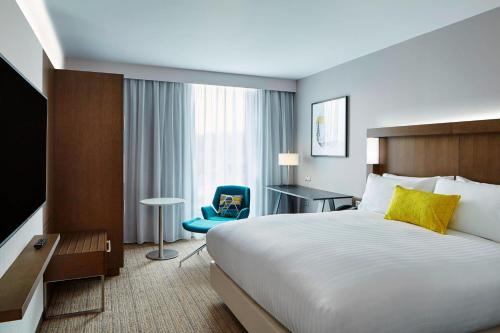a hotel room with a bed and a blue chair at Courtyard by Marriott Oxford South in Abingdon
