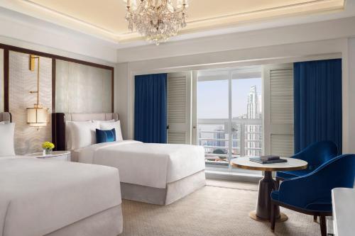 um quarto de hotel com duas camas e um lustre em The St. Regis Jakarta em Jacarta