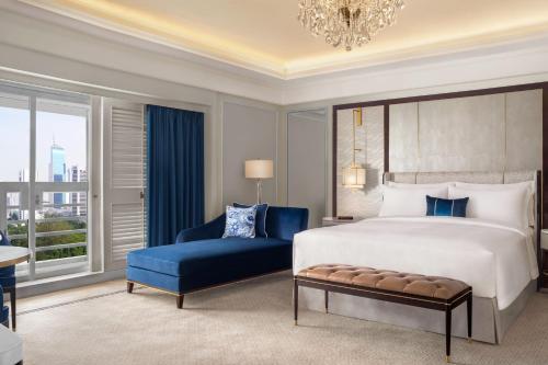 een slaapkamer met een groot bed en een blauwe stoel bij The St. Regis Jakarta in Jakarta