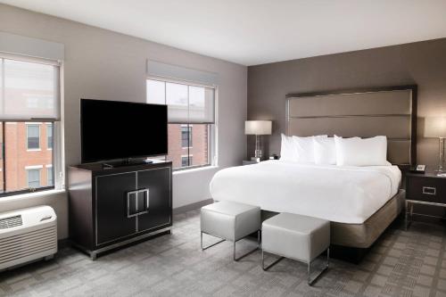 a hotel room with a bed and a flat screen tv at Residence Inn by Marriott Portsmouth Downtown in Portsmouth
