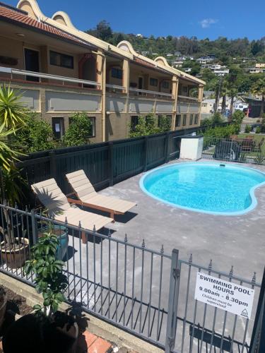 a swimming pool in front of a building at Apex Motorlodge in Nelson