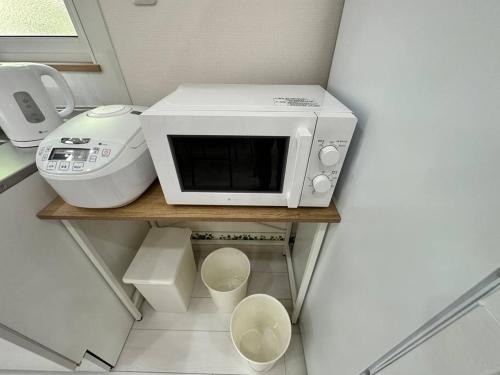 a microwave sitting on a shelf in a kitchen at SHIRAHAMA condominium D-100 in Kanayama