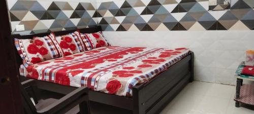 a bedroom with a bed with a red and white comforter at SAMPATH RESIDENCY in Palani