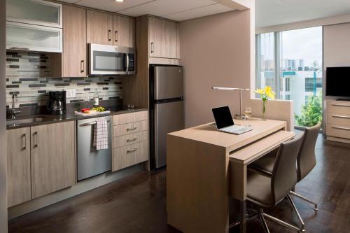 a kitchen with a kitchen island with a laptop on it at Residence Inn Miami Sunny Isles Beach in Miami Beach