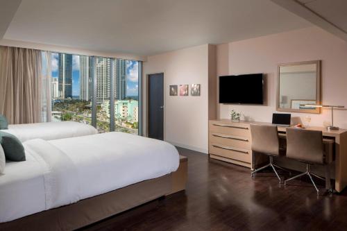 a bedroom with a bed and a desk and a television at Residence Inn Miami Sunny Isles Beach in Miami Beach