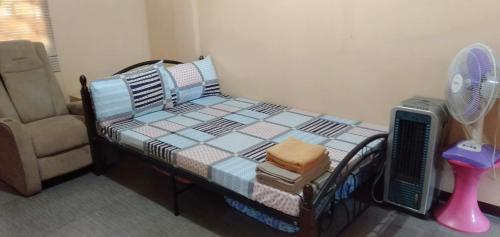 a bedroom with a bed with a fan and a chair at Lemon Transient House in Angeles