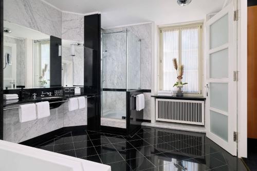 a black and white bathroom with a glass shower at Hotel Elephant Weimar, Autograph Collection in Weimar