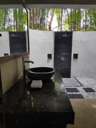 uma casa de banho com um lavatório e uma banheira em Villa Damai Shanti em Ubud