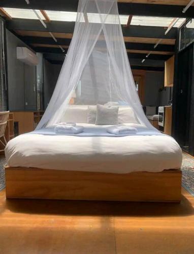 a bed with a mosquito net on top of it at Francis Lane Tiny Studio in Adventure Bay