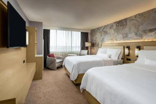 a hotel room with two beds and a flat screen tv at The Westin Tysons Corner in Tysons Corner