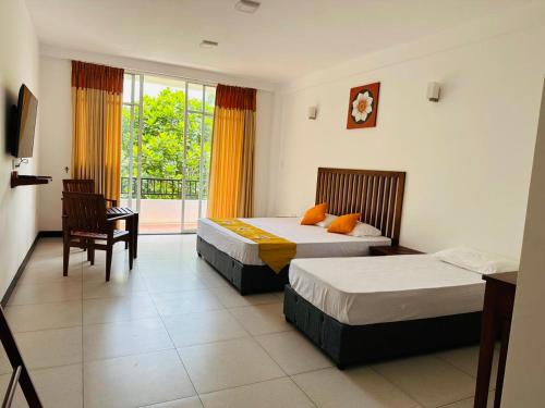 a hotel room with two beds and a balcony at Kandy Hub Guest House in Kandy