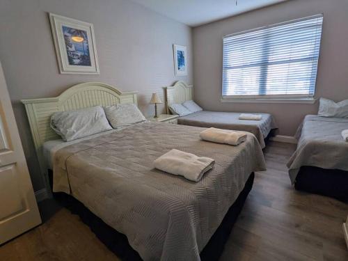 a bedroom with two beds with towels on them at Nice & Cozy - Vacation Home in Kissimmee