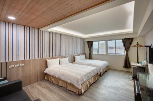 花蓮市にある天璽商務飯店 Cullinan Hotelのベッド2台とテレビが備わるホテルルームです。